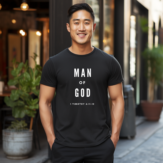 smiling man wearing a black T-shirt. The T-shirt has the text "MAN OF GOD" written prominently in bold white letters